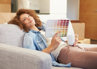 Woman on sofa: Homeowner choosing home improvement from colour range