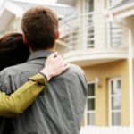 Homeowners satisfied with their new home improvement products; hug, yellow house, couple