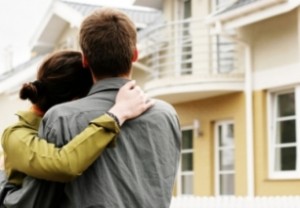 Homeowners satisfied with their new home improvement products; hug, yellow house, couple
